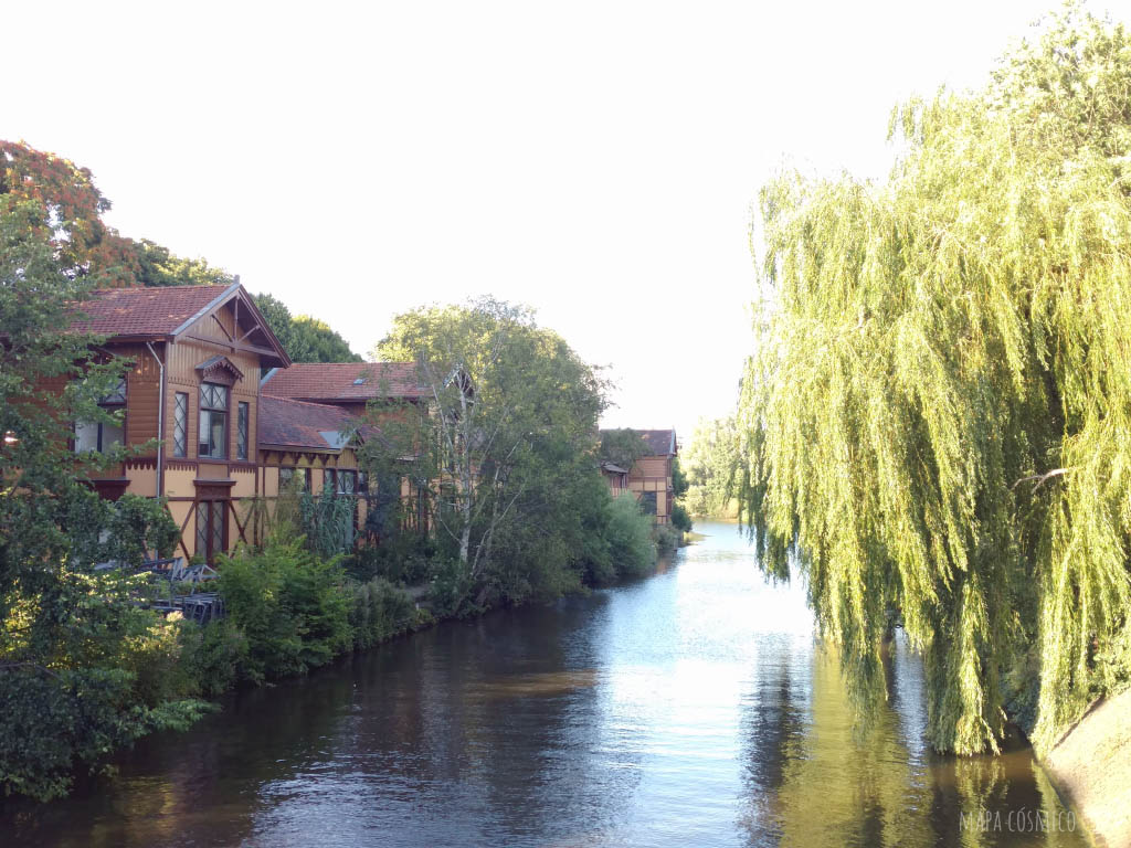 canal en Amsterdam, río, árboles verdes y casitas sobre el agua